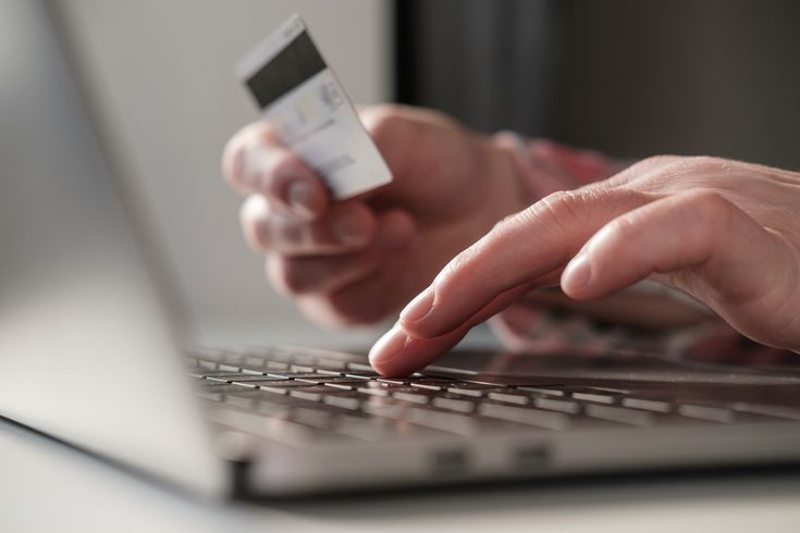 a man using a credit card on a computer entering his sort code and account number
